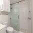 Guest bathroom remodel with walk-in shower, sliding glass enclosure, subway tile walls, and pebble shower floor.